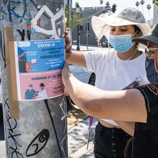 Two women pinning info on a post